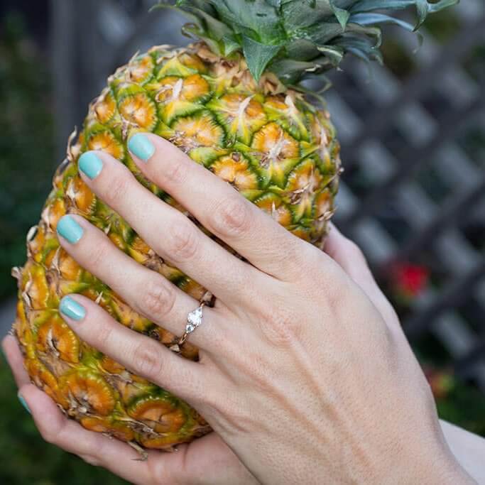 drive-swim-fly-pineapple-collection-real-fruit-holding-pineapple-hands-engagement-ring-wedding-ring-outdoors-backyard-header